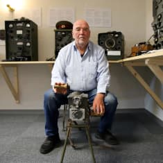 Rainer Böling esittelee aggregaattia Närpiön kotiseutumuseossa Stella Polaris -näyttelyssä, taustalla vanhaa radioteknologiaa.