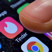 Ett finger närmar sig appen tinder på en smarttelefonskärm