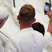 Pariskunta ottaa paavin kanssa selfien.