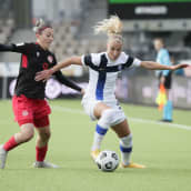 Suomen Emma Koivisto ohittaa pallon kanssa Georgian Irina Khaburdzanian jalkapallon MM-karsintaottelussa Suomi–Georgia. Ottelu Helsingissä 12. huhtikuuta 2022.