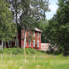 Rött hus sett från en åker.