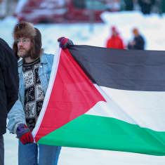 Kolme mielenosoittajaa, joilla Gazan lippu.