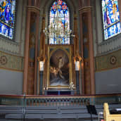 Kirkon alttarin yläpuolella on Jeesusta esittävä alttaritaulu ja lasimaalaukset.