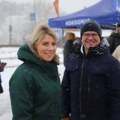 Kansanedustajat Saara-Sofia Sirén ja Petteri Orpo sankassa lumisateessa kokoomuksen vaalikojun edustalla.