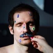 Henkilön kasvoihin laitetaan tarroja.