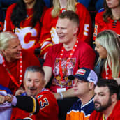 Brady Tkachuk istuu katsomossa Calgary- ja Edmonton-fanien keskellä.