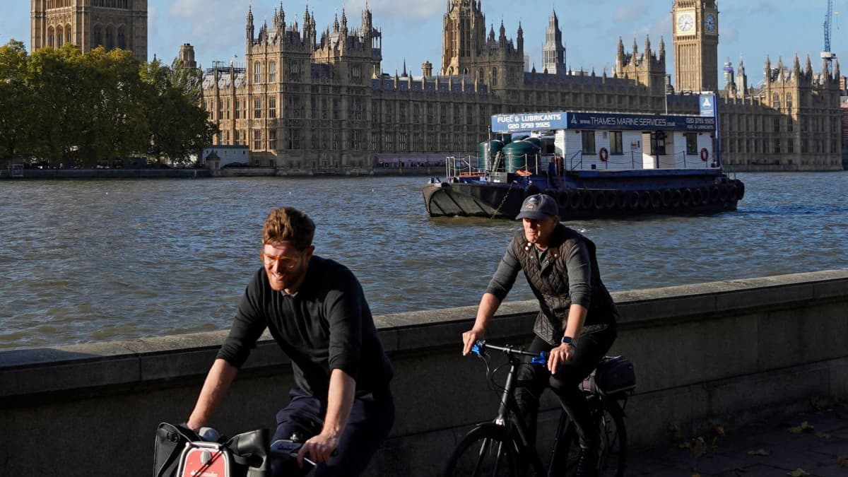 Kaksi pyöräilijää Thamesin rannalla, taustalla wesminster ja Big ben