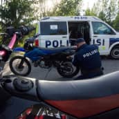 En polis lossar en registerskylt från en moped.
