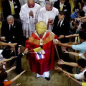 Paavi seurakuntalaisten ympäröimänä.