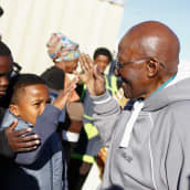 Desmond Tutu tervehtii lapsia.