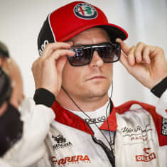 Kimi Räikkönen tar på sig solglasögonen.