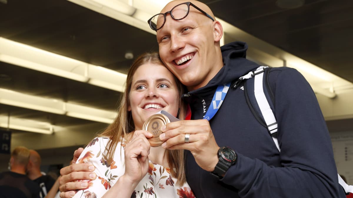 Matti Mattsson visar upp sin bronsmedalj tillsammans med frun Maiju.
