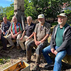 Sex äldre män som sitter på en kvarnfot.