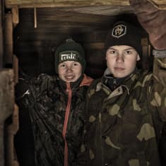 Aulis ja Eelis Lötjönen seisovat rakentamansa korsun oviaukossa ja katsovat kameraan.