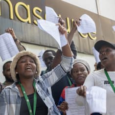 Kenialaisia nuoria aikuisia Facebook-moderaattoreita osoittamassa mieltään, kädessä paperiset oikeuden päätökset. 