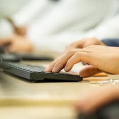 Gradian opiskelija kirjoittaa tietokoneella.