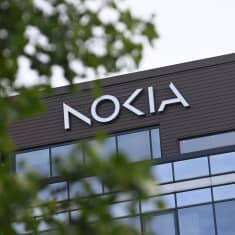 Nokian pääkonttorin julkisivu, jonka alaosassa on ikkunoita. Keskellä kuvaa rakennuksen seinällä on Nokian logo.