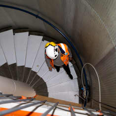 Tomi Nurminen kävelee portaita alas. Hänellä on oranssi huomioliivi ja kypärä.