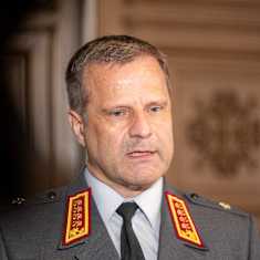 A man speaking to cameras dressed in an army uniform.