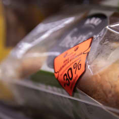 Oranssi kolmenkymmenen prosentin alennustarra  muoviin pakatun elintarvikkeen päällä kaupan kylmähyllyssä.