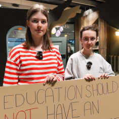 Två gymnasieelever håller i ett plakat.