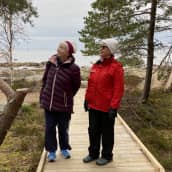 Pietarsaaren vammaisneuvoston sihteeri Maire Paavola ja liikuntatoimenjohtaja Tove Jansson Fäbodan esteettömällä luontopolulla. Taustalla syksyinen meri ja rantaluonto.