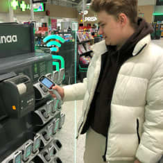 Asiakas Niko Niemeläinen palauttaa skannauslaitetta Turussa Tampereentien Prismassa.