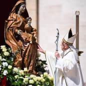 Paavi koskettaa patsasta.