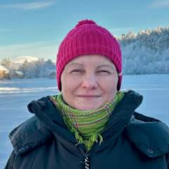 Nainen katsoo kameraan, taustalla tunturimaisema. Erva Niittyvuopio. 