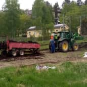 Tampereen viljelypalstoille levitetään kompostoitua hevosenlantaa. Hommissa traktori, kuski ja lannanlevityskärry. 