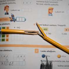 En brusten penna på en skolbok.