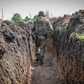 Ukrainalainen sotilas kävelee juoksuhaudassa.