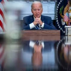USA:s president Joe Biden sitter vid ett skrivbord.