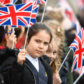 Koululaiset heiluttavat pieniä Britannian lippuja.