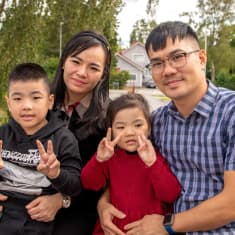 Vietnamista Suomeen saapunut perhe istuu Virtain terveyskeskuksen edessä penkillä. Kuvassa on äiti, 6-vuotias poika, 5-vuotias tyttö ja isä. Lapset näyttävät sormillaan rauhan merkkiä.
