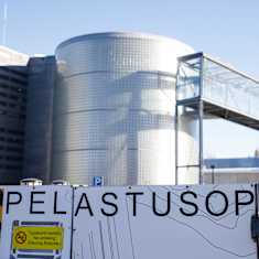 Pelastusopiston kyltti ja rakennuksia Kuopion Petosella.
