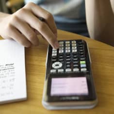 Nuori laskee matematiikan tehtäviä.