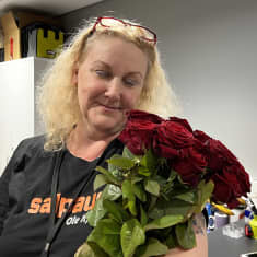 Koulutuskeskus Salpauksen vahtimestari Nina Soramäki sai ruusukimpun naistenpäivänä. Nina pitelee kimppua katsoen sitä.