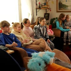 Ukrainasta Suomeen sotaa pakoon lähteneet kolme äitiä viiden lapsensa kanssa istuvat sohvalla hausjärveläisen talon sohvalla. 