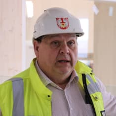 En man med hjälm på huvudet står i en byggnad.