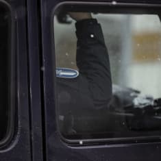 Poliisin panssaroitu ajoneuvo Poliisitalo 2 edessä Helsingin Pasilassa. Kuvassa lähikuva poliiin kädestä ja hihamertkistä.