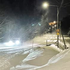 Luminen maantie ja lumipyryä, pöllyävää lunta.