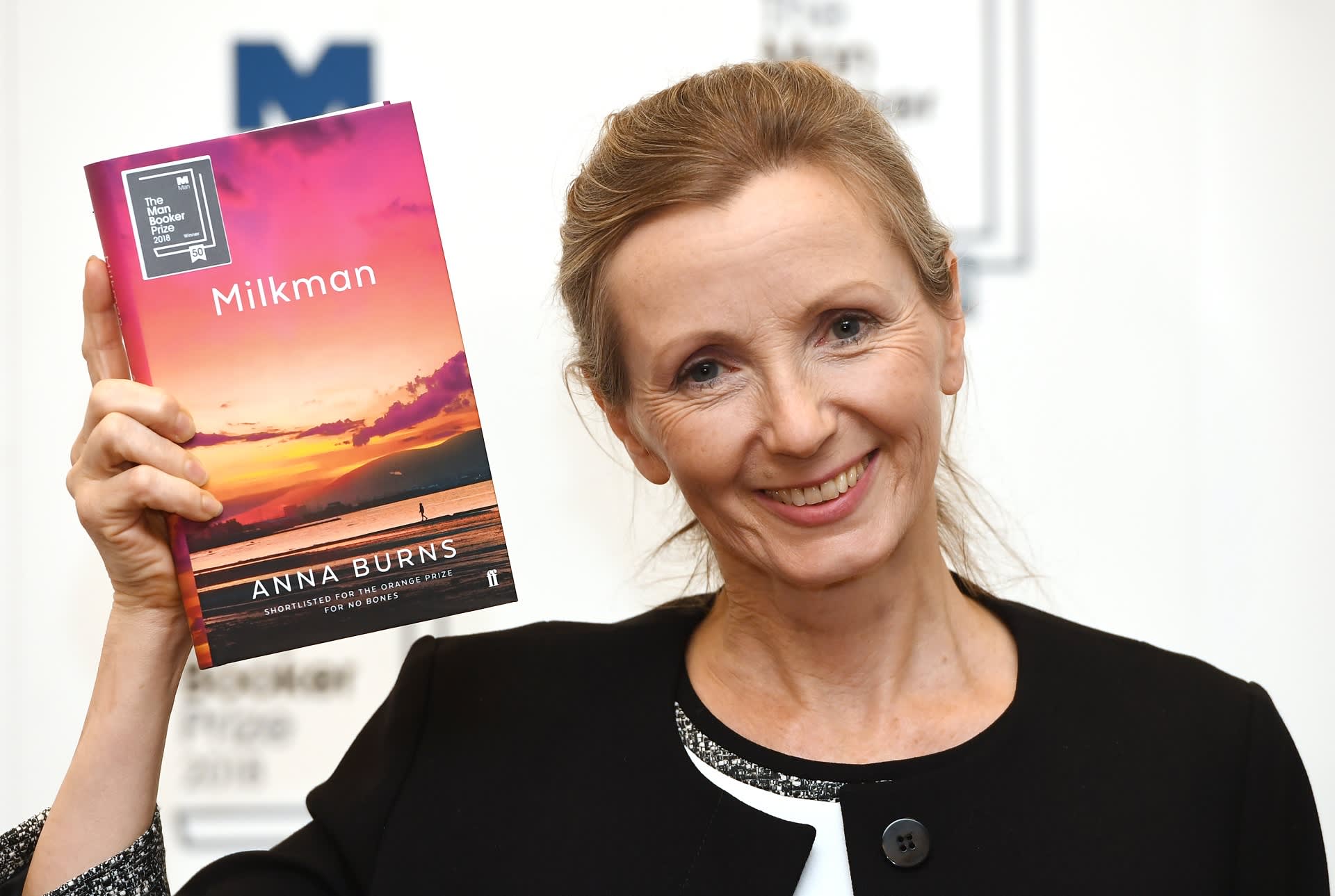 Kirjailija Anna Burns nostaa hymyillen kirjoittamaansa voittajateosta.