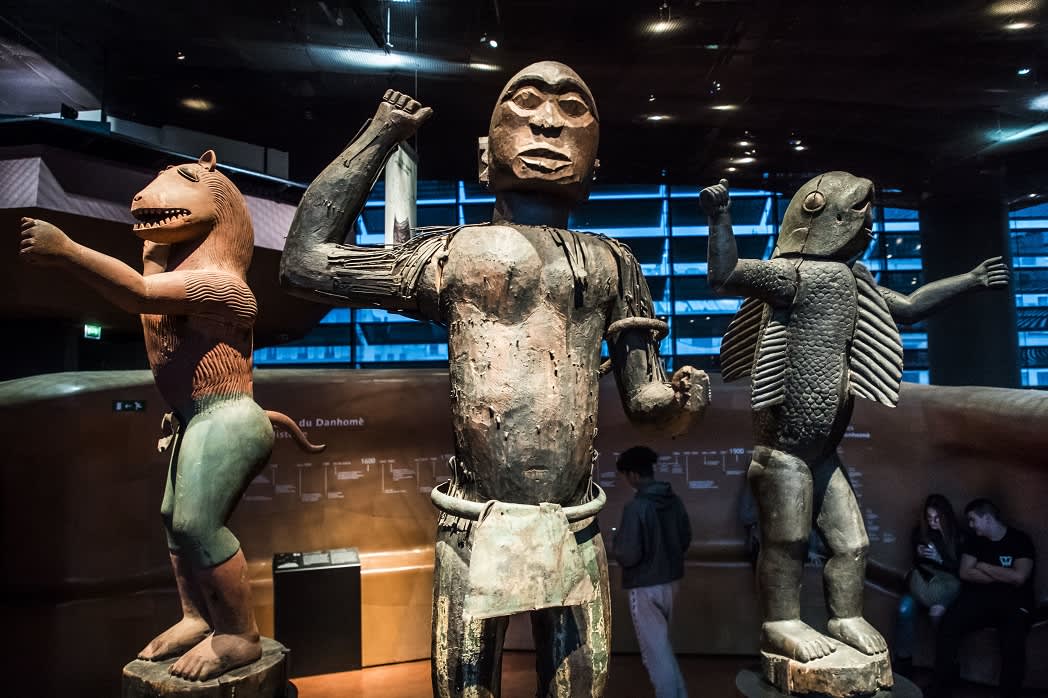 Kolme patsasta, joista yhdellä on kalan vartalo ja ihmisen käden ja jalat.