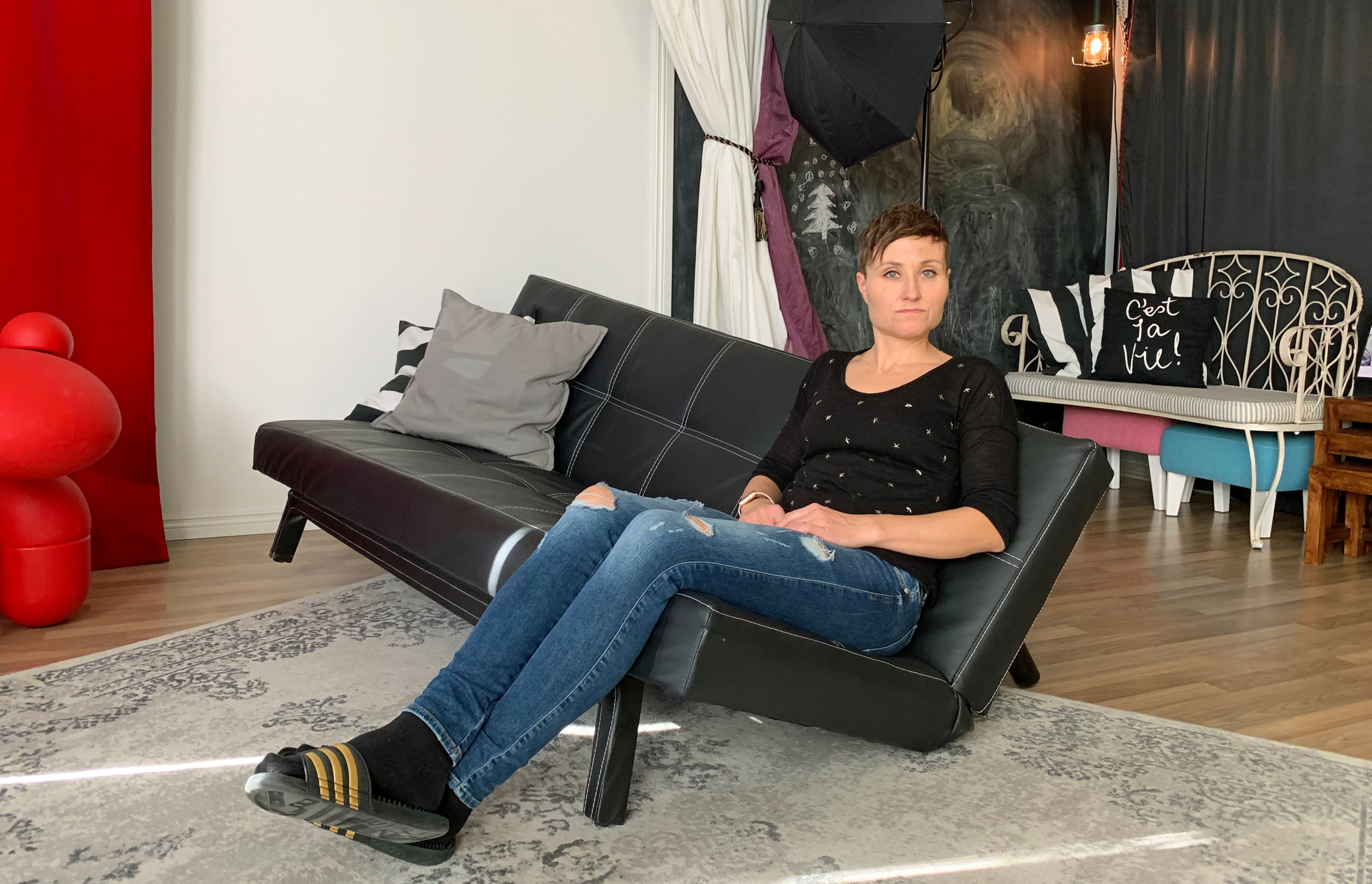 Heidi Noponen istuu risalla sohvalla