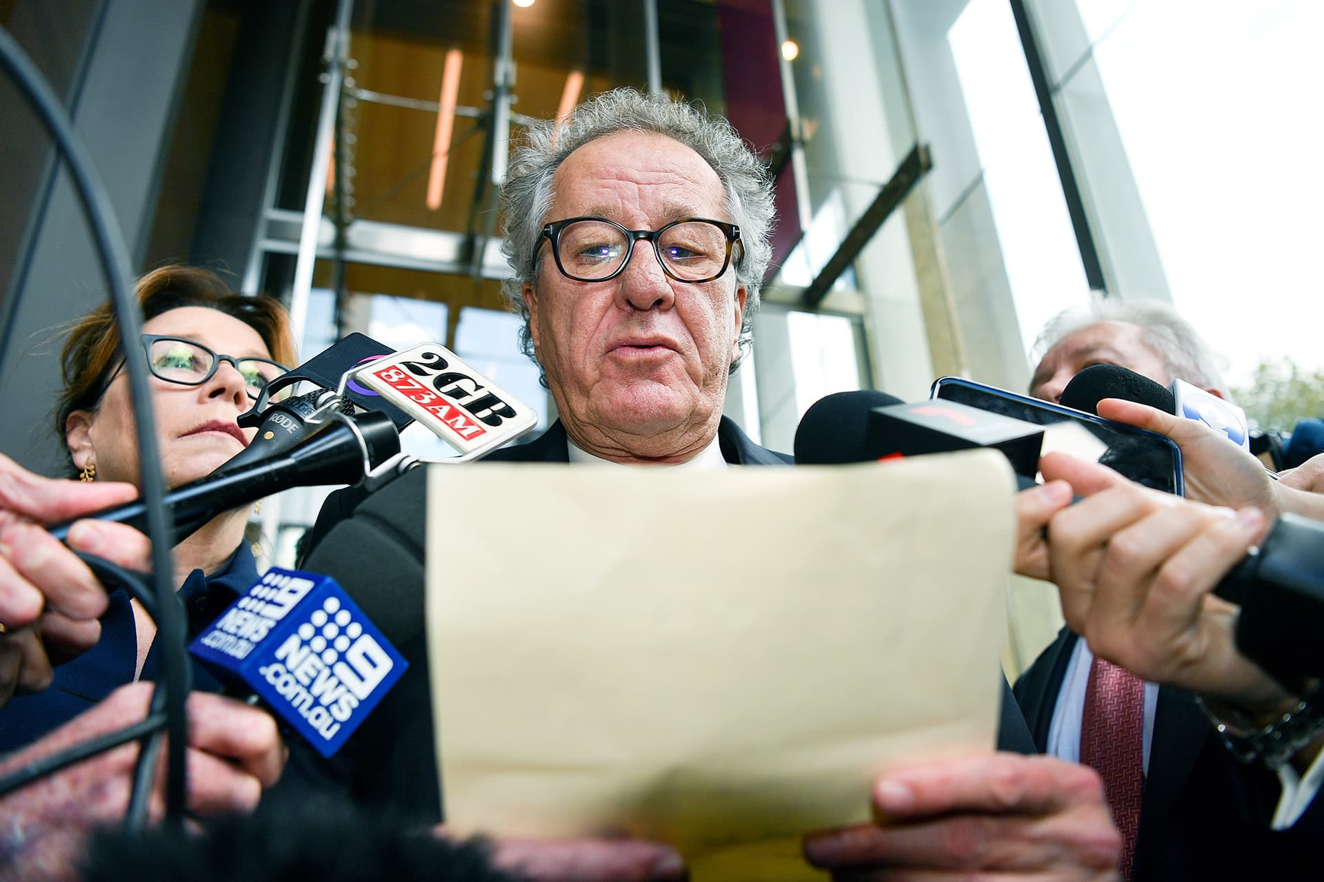 Näyttelijä Geoffrey Rush (kesk.) antaa lehdistötiedotteen korkeimman oikeuden ulkopuolella Sydneyssä.