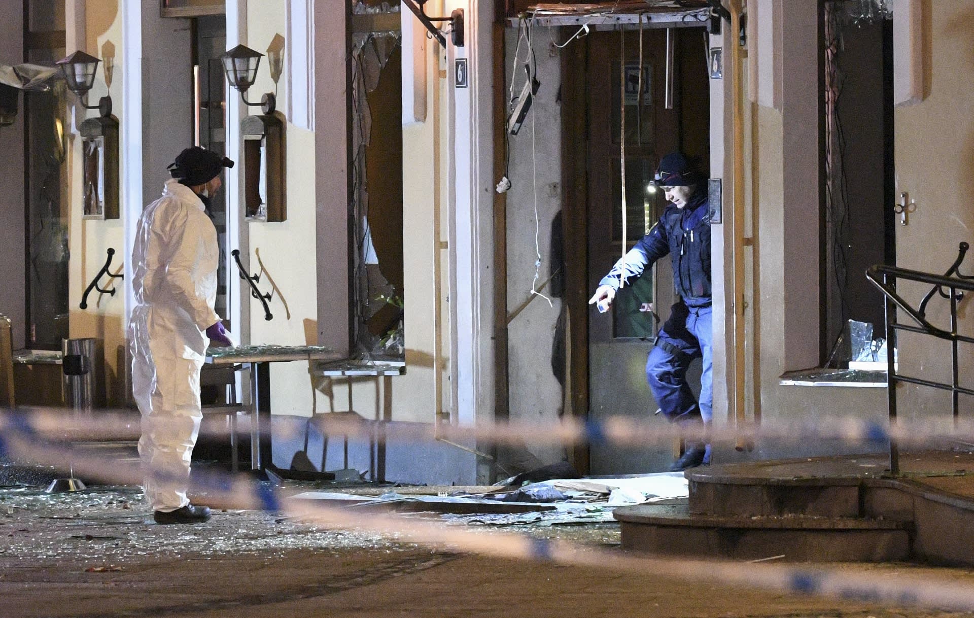 Poliisin tutkijat räjähdyksessä vaurioituneen ravintolan edustalla.