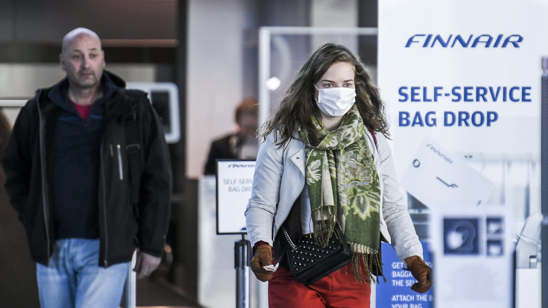 Suu- ja nenäsuojainta käyttävä matkustaja Helsinki-Vantaan lentokentällä.