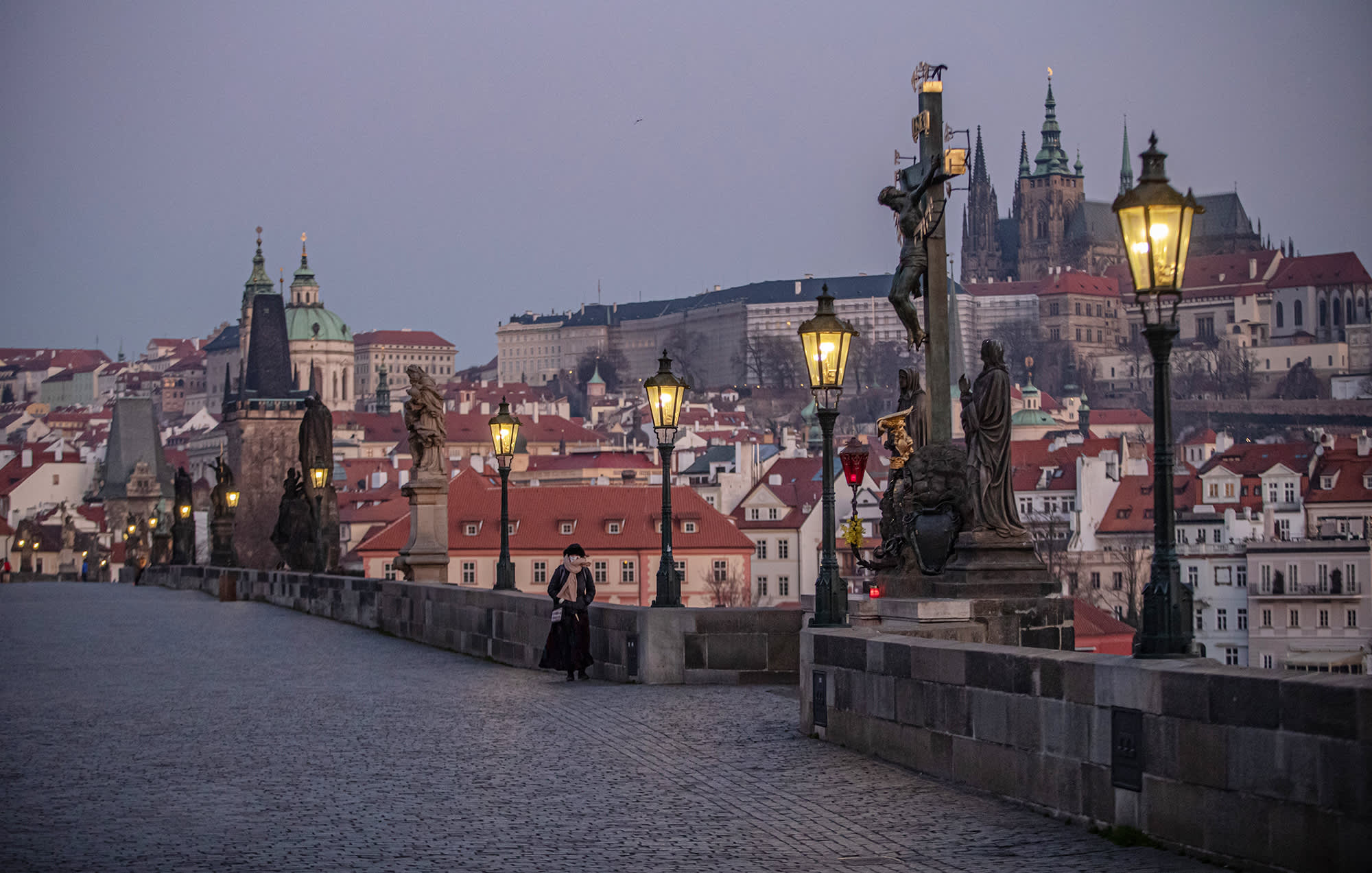 Nainen kävelee Kaarlen sillalla Prahassa.