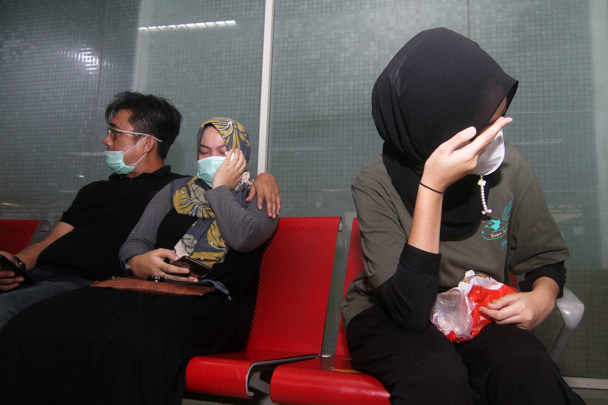 Kadonneiden matkustajien omaiset itkevät lentokentällä.